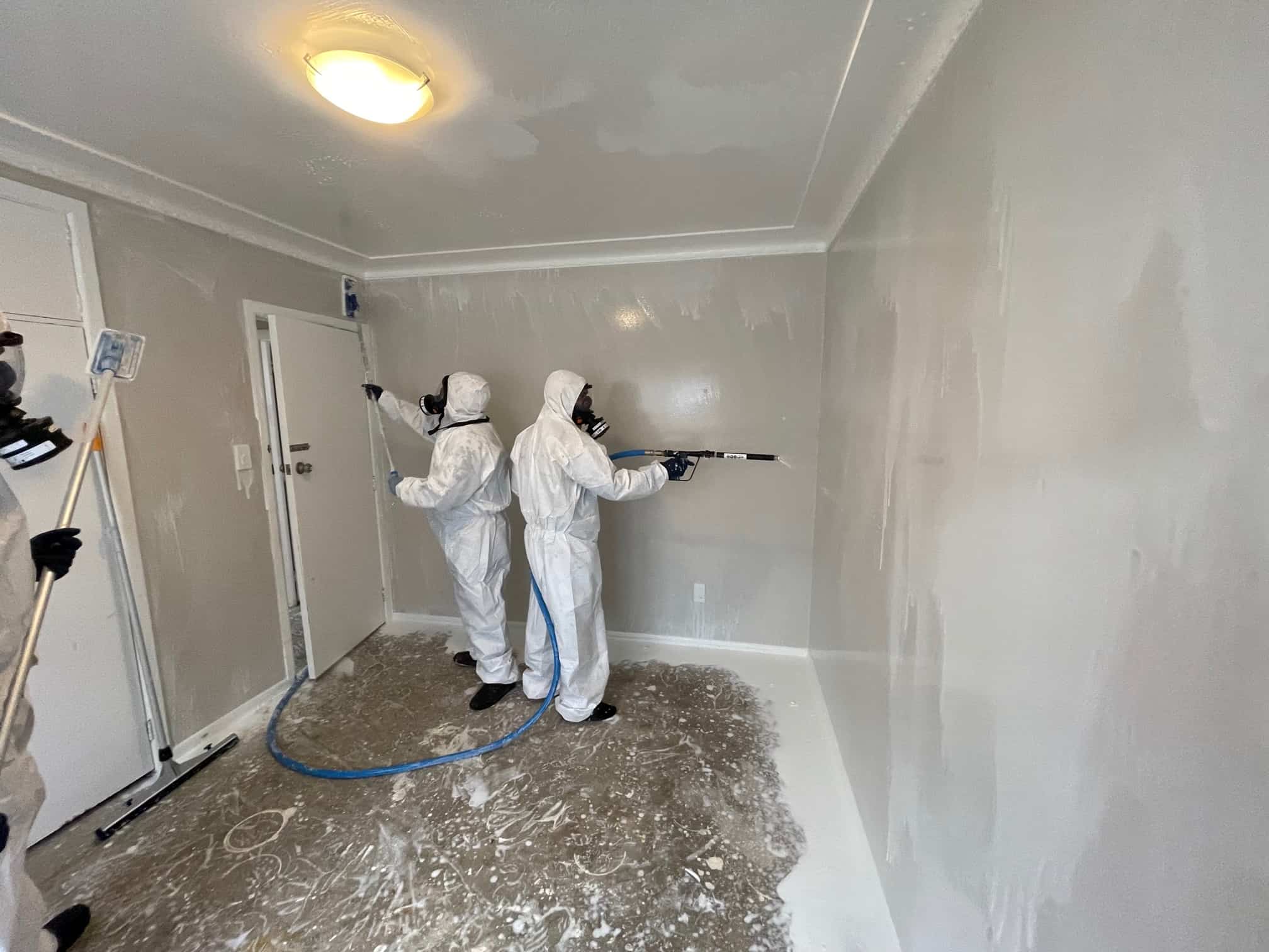 iDry technicians spraying decontamination solution on walls during meth cleanup in Auckland